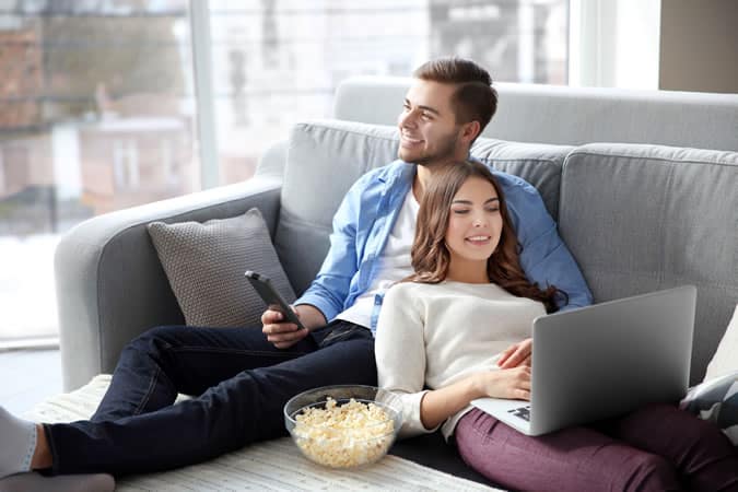 Man lazing in front of the TV with his partner