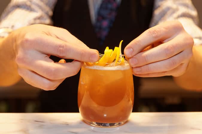 Garnishing a cocktail with lemon zest