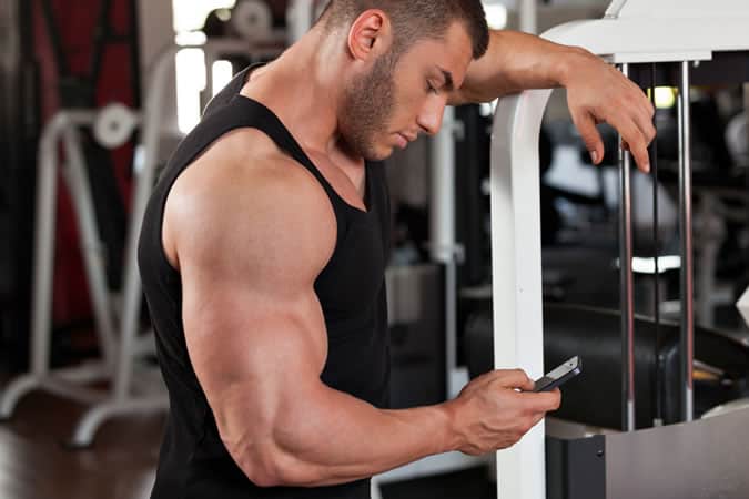 man checking his phone in the gym