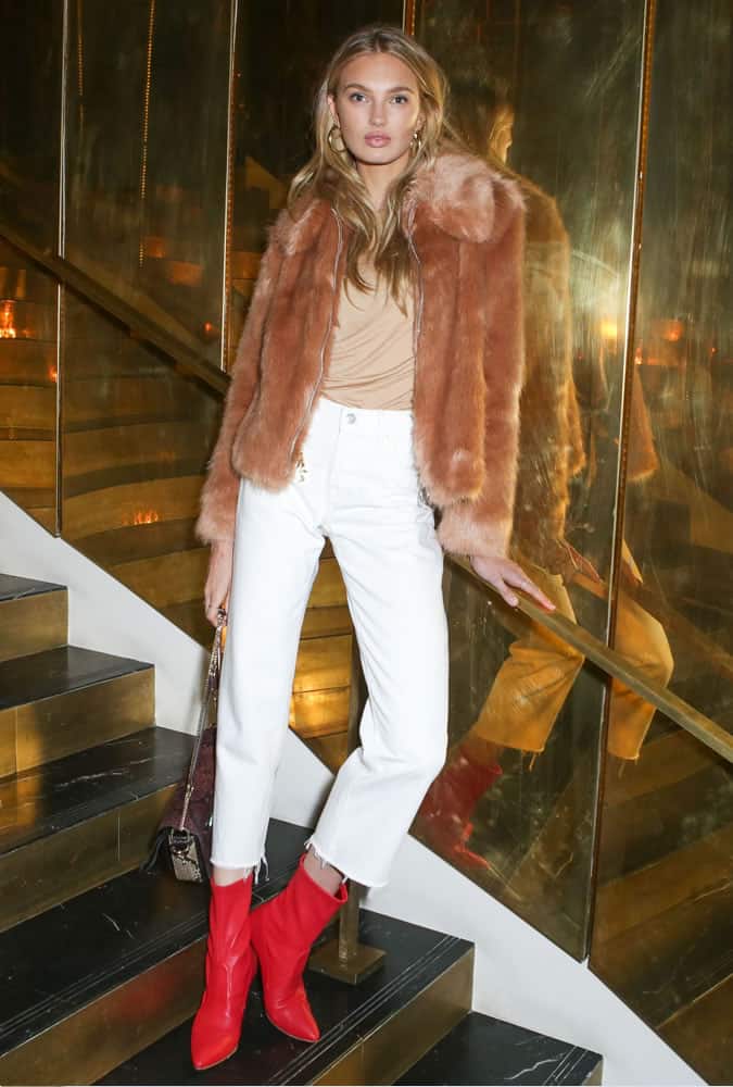 Romee Strijd wearing white jeans and a camel coat