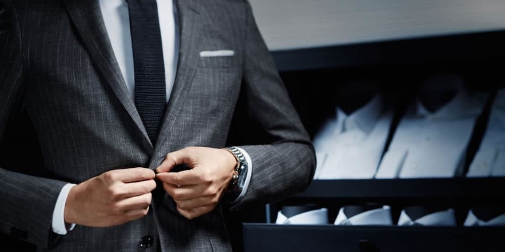 Man Dressed In A Grey Suit With A Navy Tie