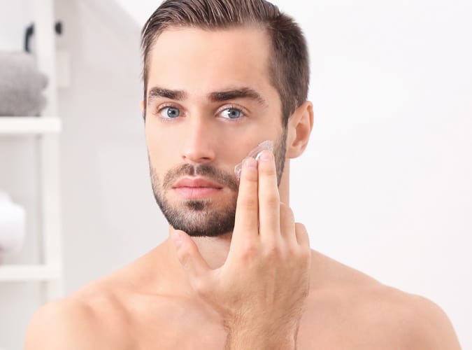 Man Applying Moisturiser To His Face