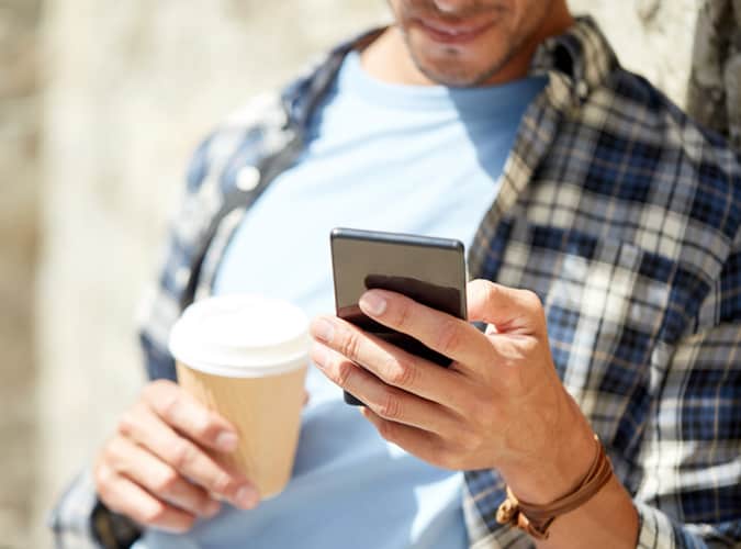 Man Looking At His Phone Outdoors