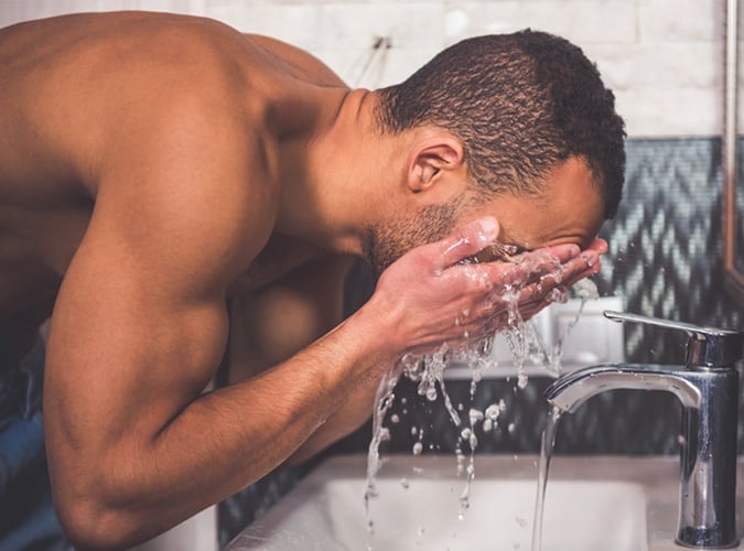 man washing face