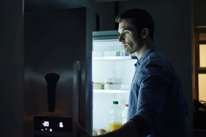 Man Looking in a fridge at night