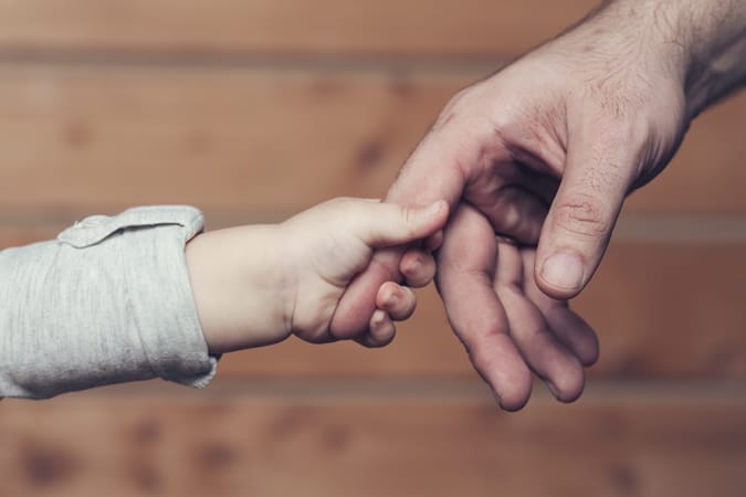 Child holding fathers hand