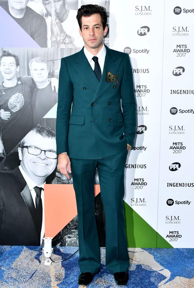 MArk Ronson wearing a green double-breasted suit with flared trousers