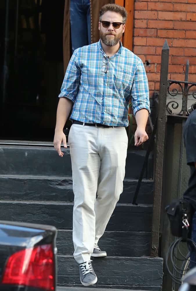 Seth Rogen wearing a check shirt and wide leg trousers