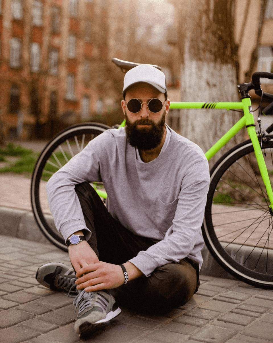 man who used a beard straightener sitting in front of a bike