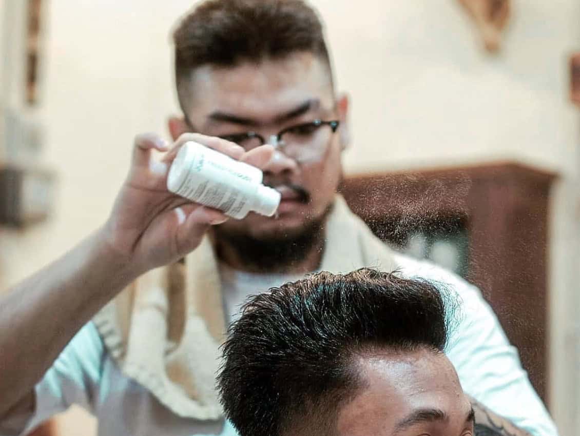 Barber applying hair powder to a haircut
