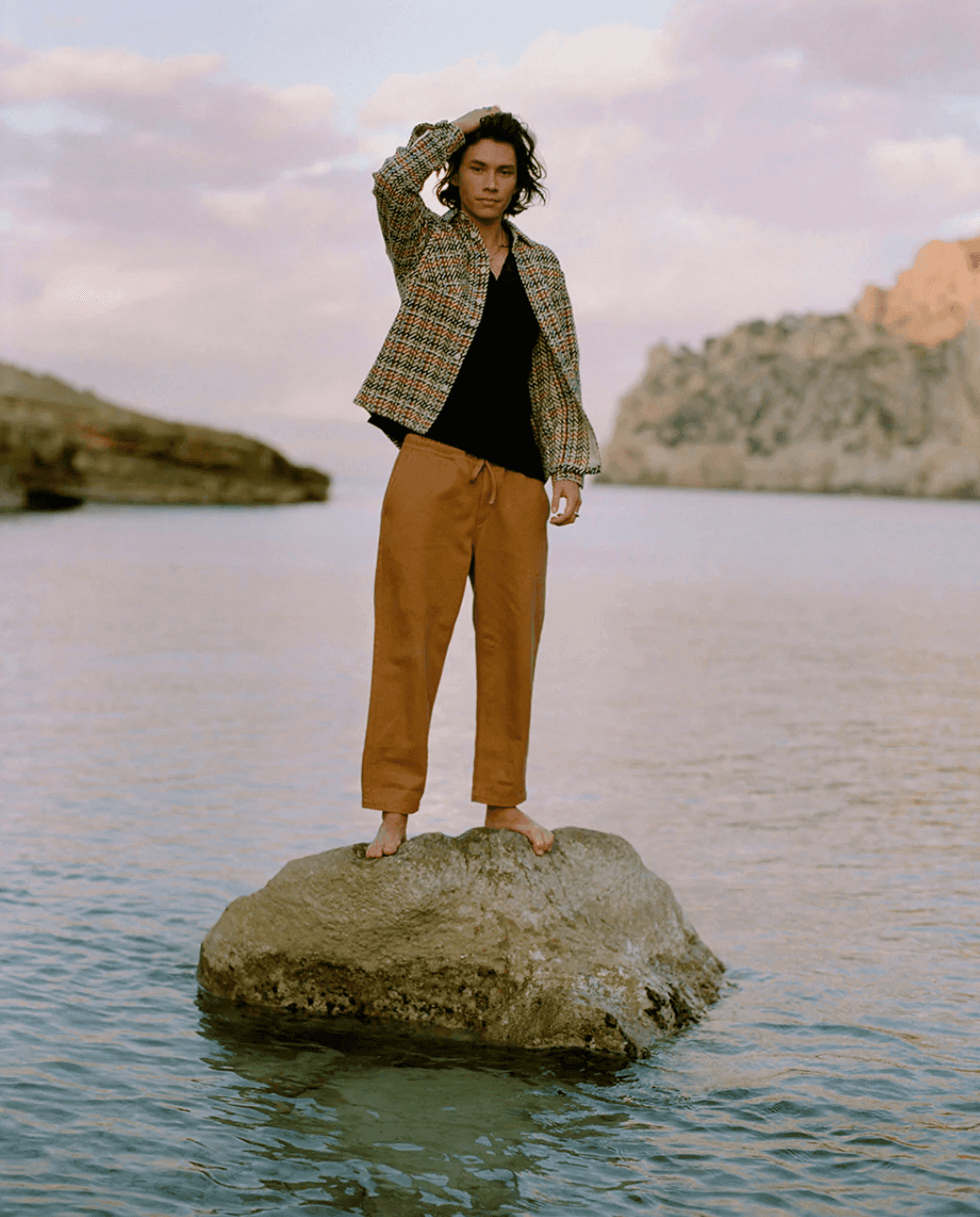 Man standing on a rock in a body of water