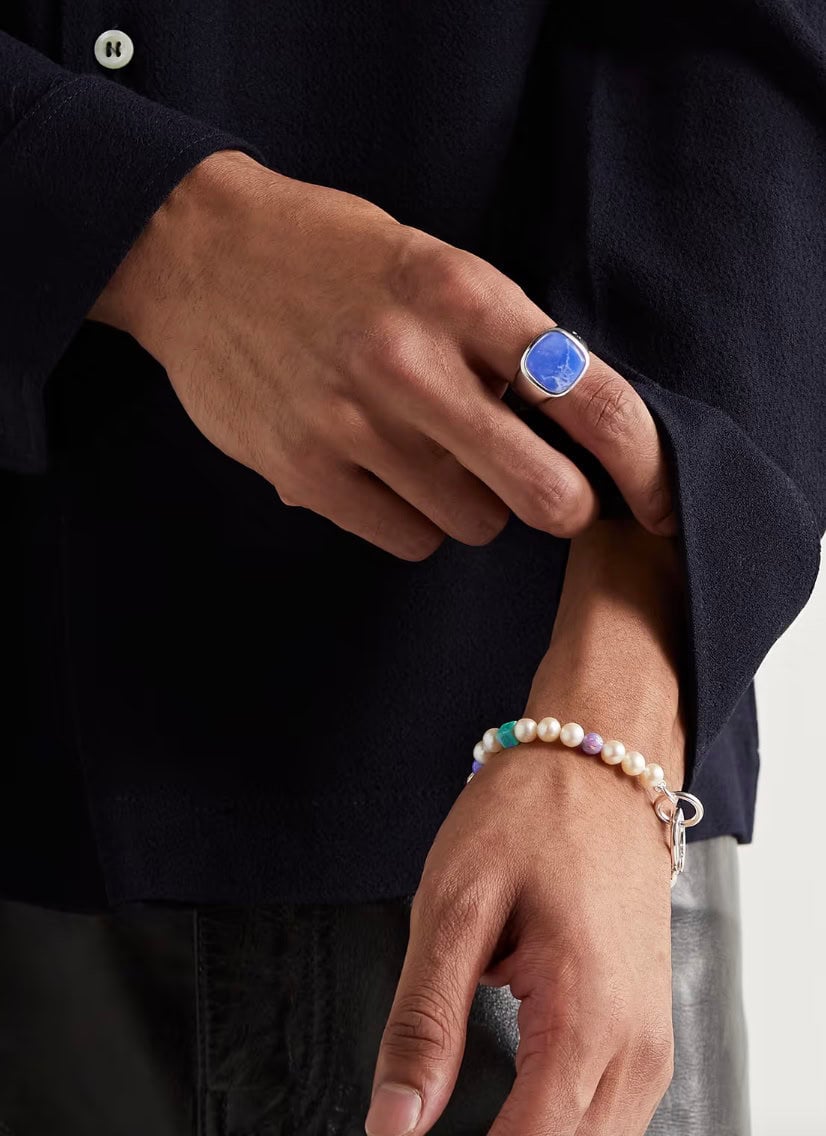 man wearing blue signet ring and pear bracelet