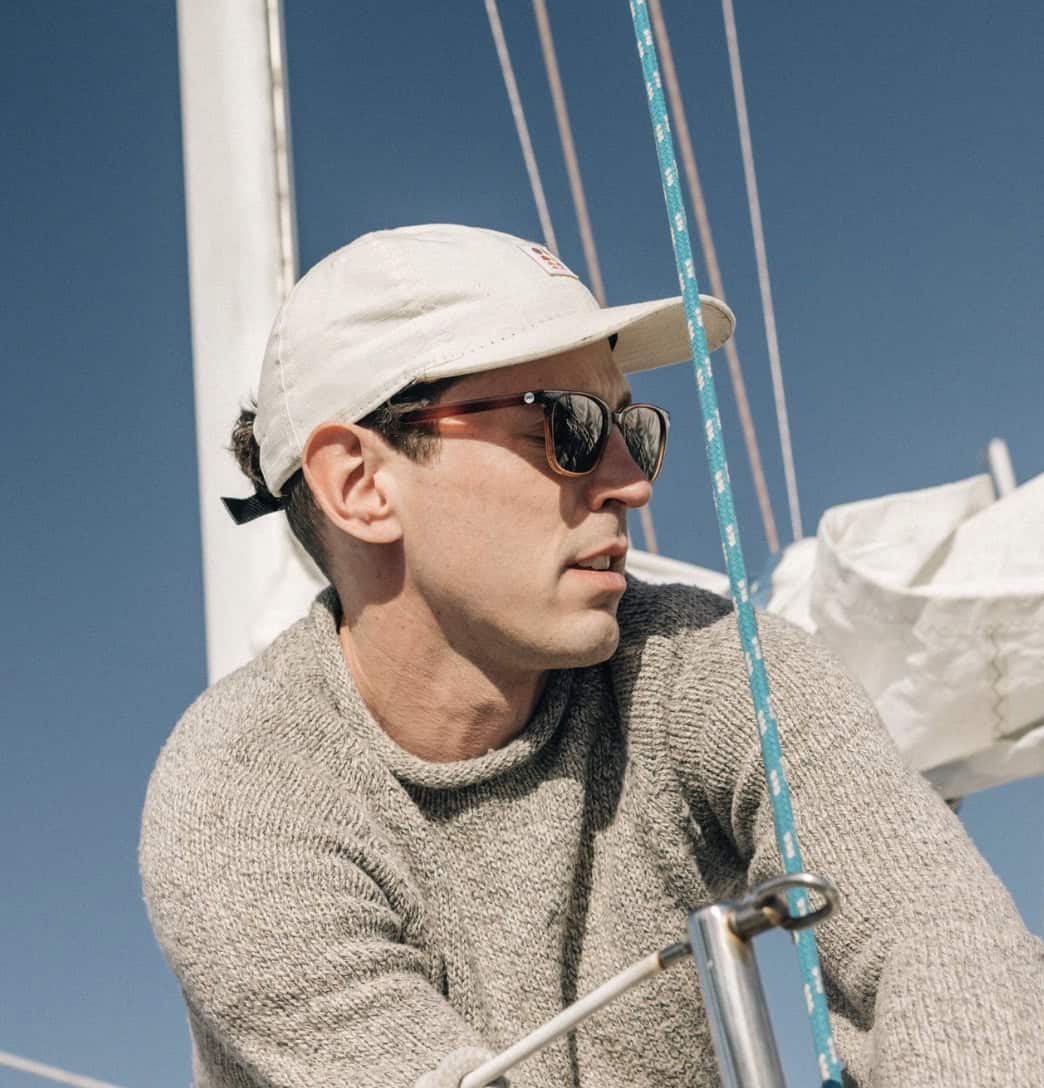 Man on a boat leading on ropes, wearing a