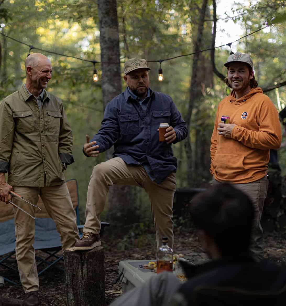 three men standing in the woods, smiling or talking
