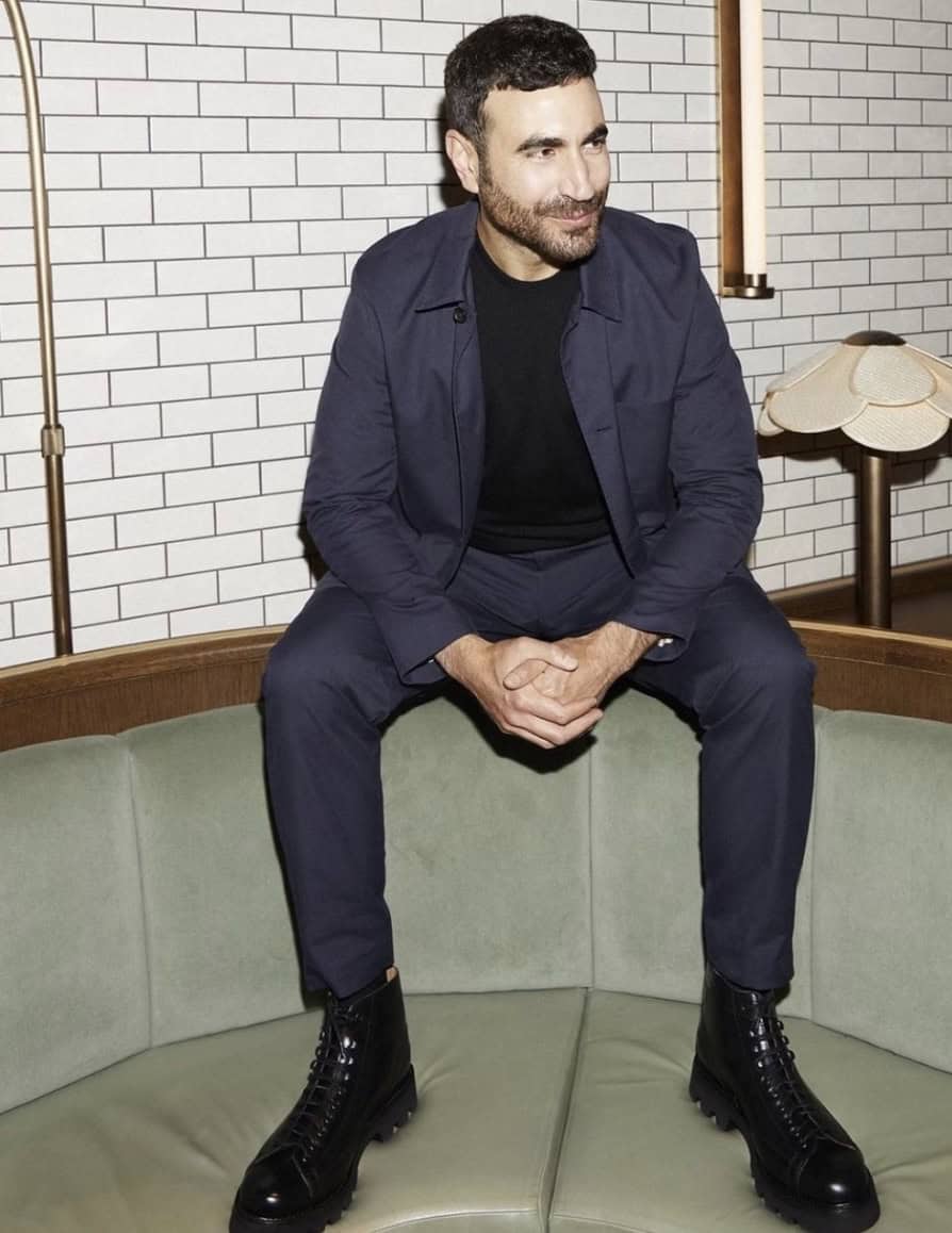 Man sitting on the back of a booth with boots on the seat