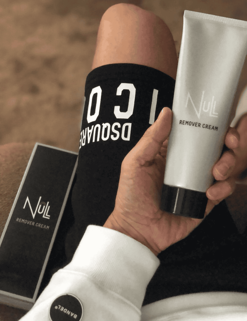 man holding a bottle of hair removal cream in his lap