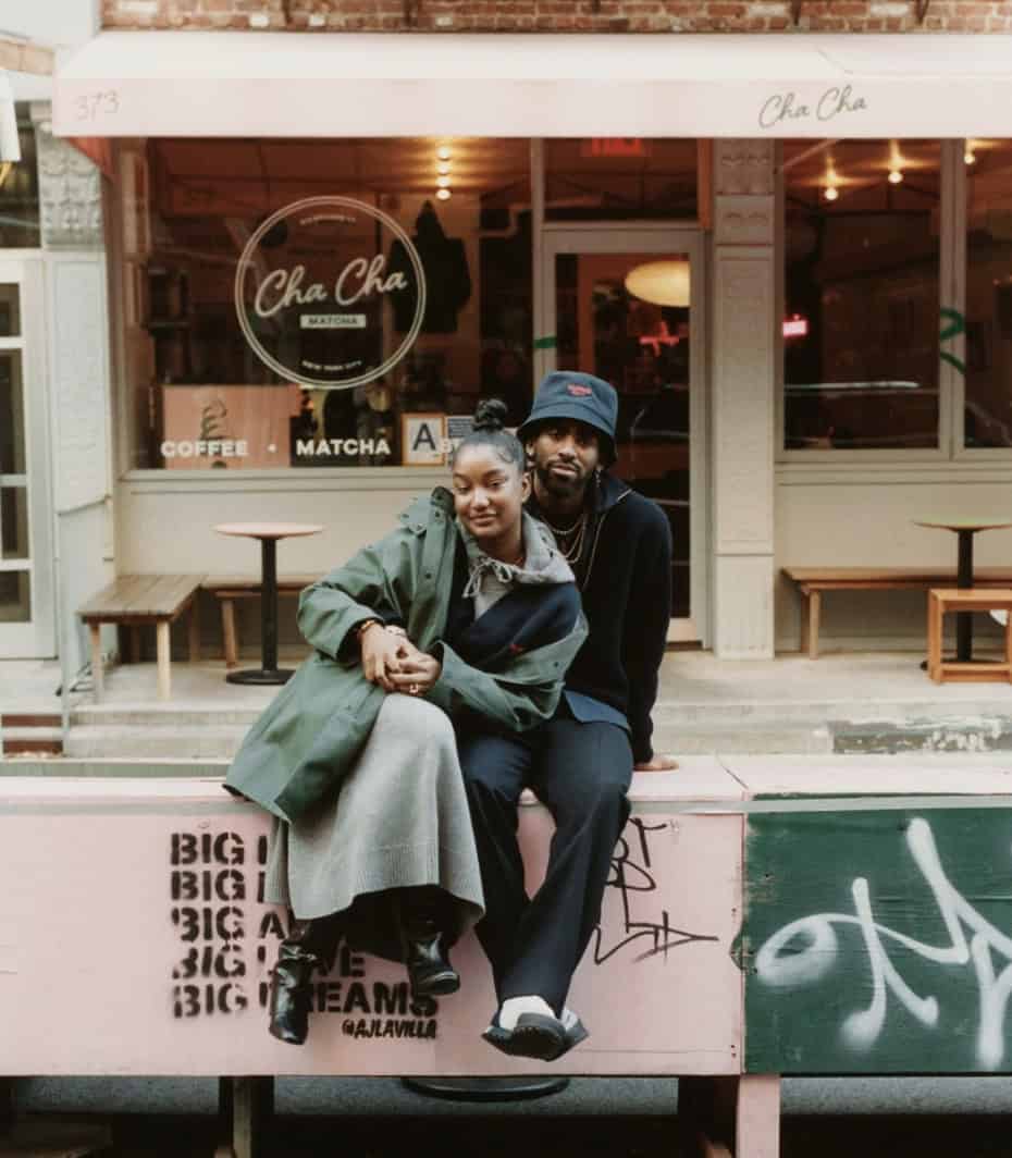couple sitting outside a store, smiling