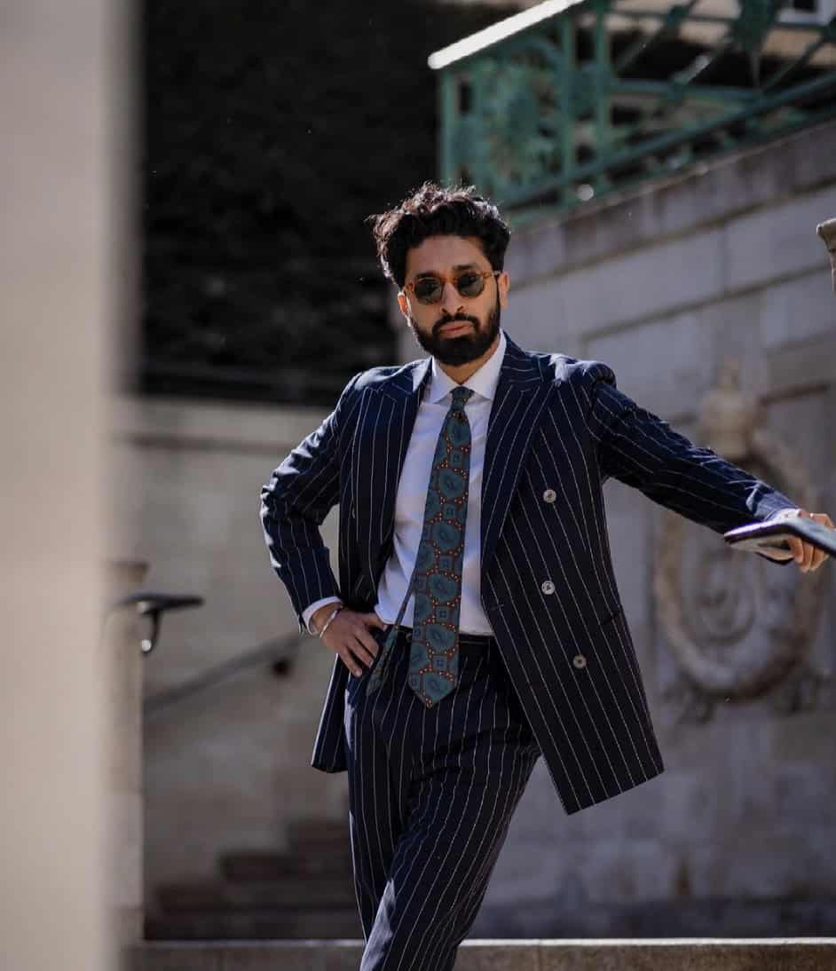 man leaning against a building in a suit