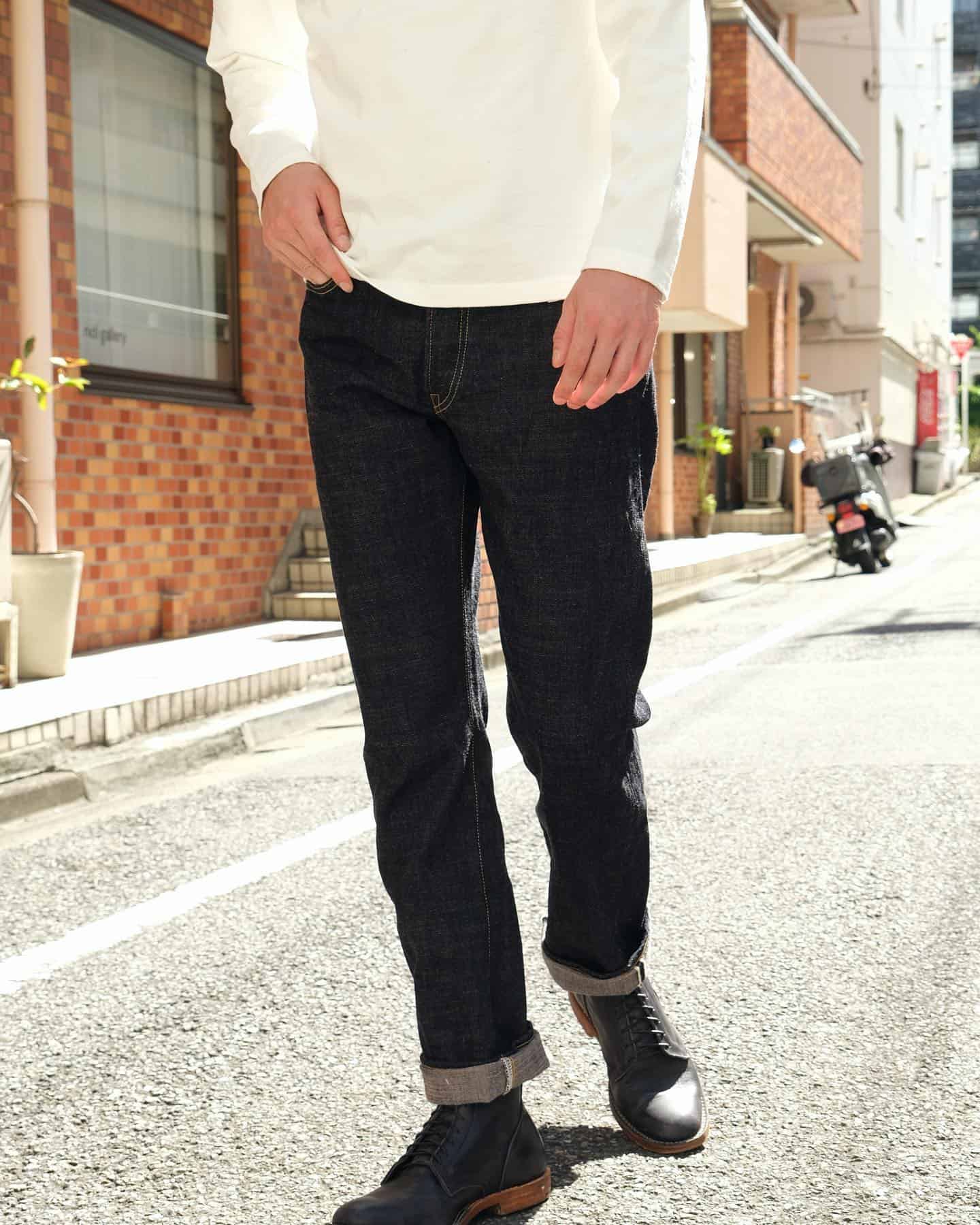 Man wearing white top and black Japanese denim pants