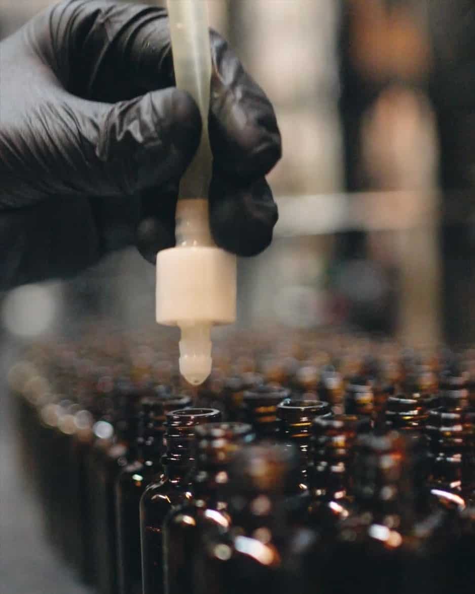 Refilling beard growth oil in amber dropper bottles
