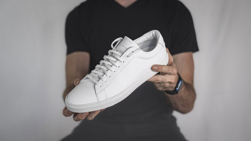 man holding out an Oliver Cabell Low 1 shoe