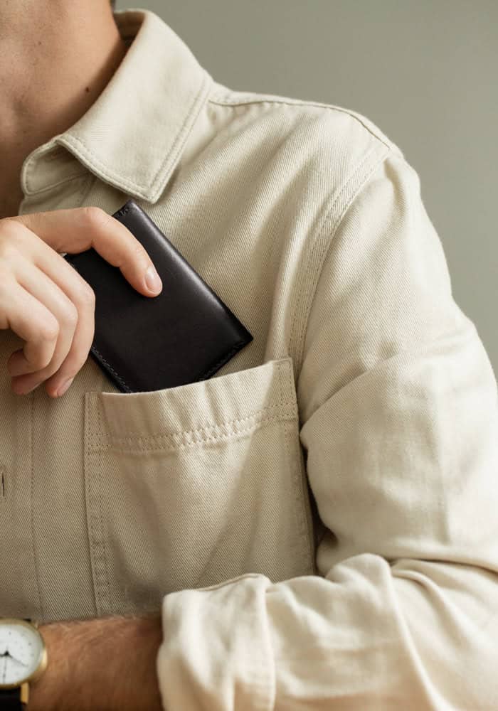 Man slipping bifold wallet in his pocket