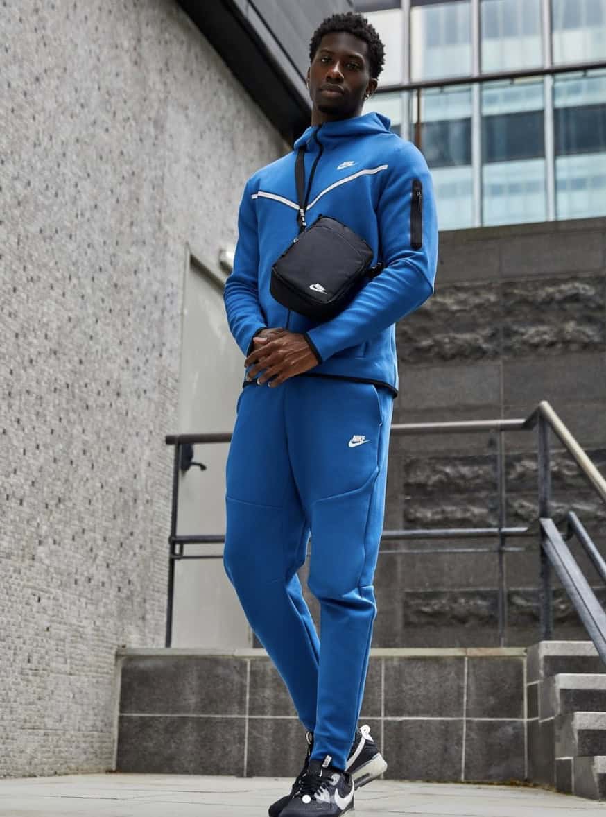 man standing on stairs in a matching blue jumpsuit