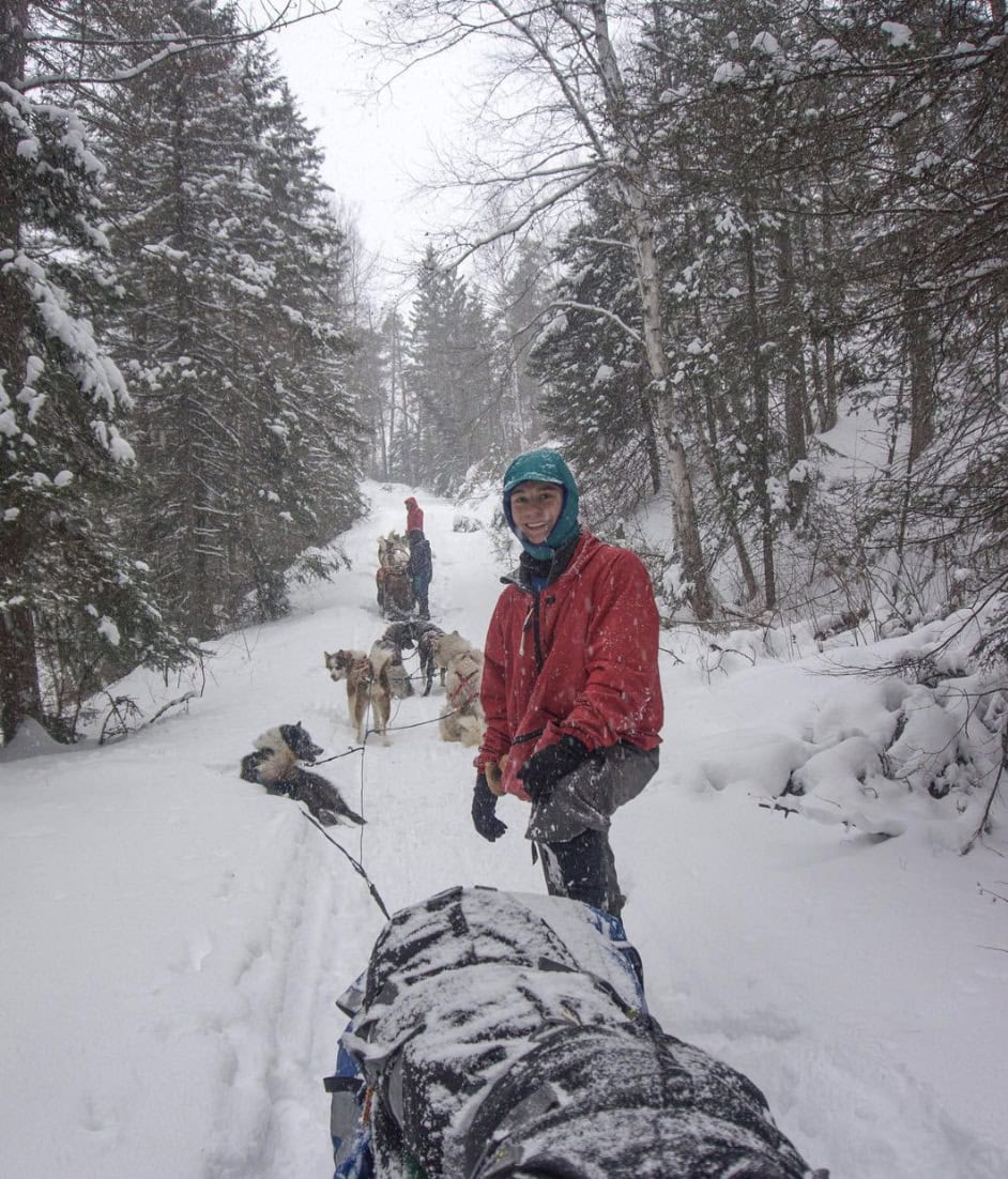 men and dogs walking in the snow