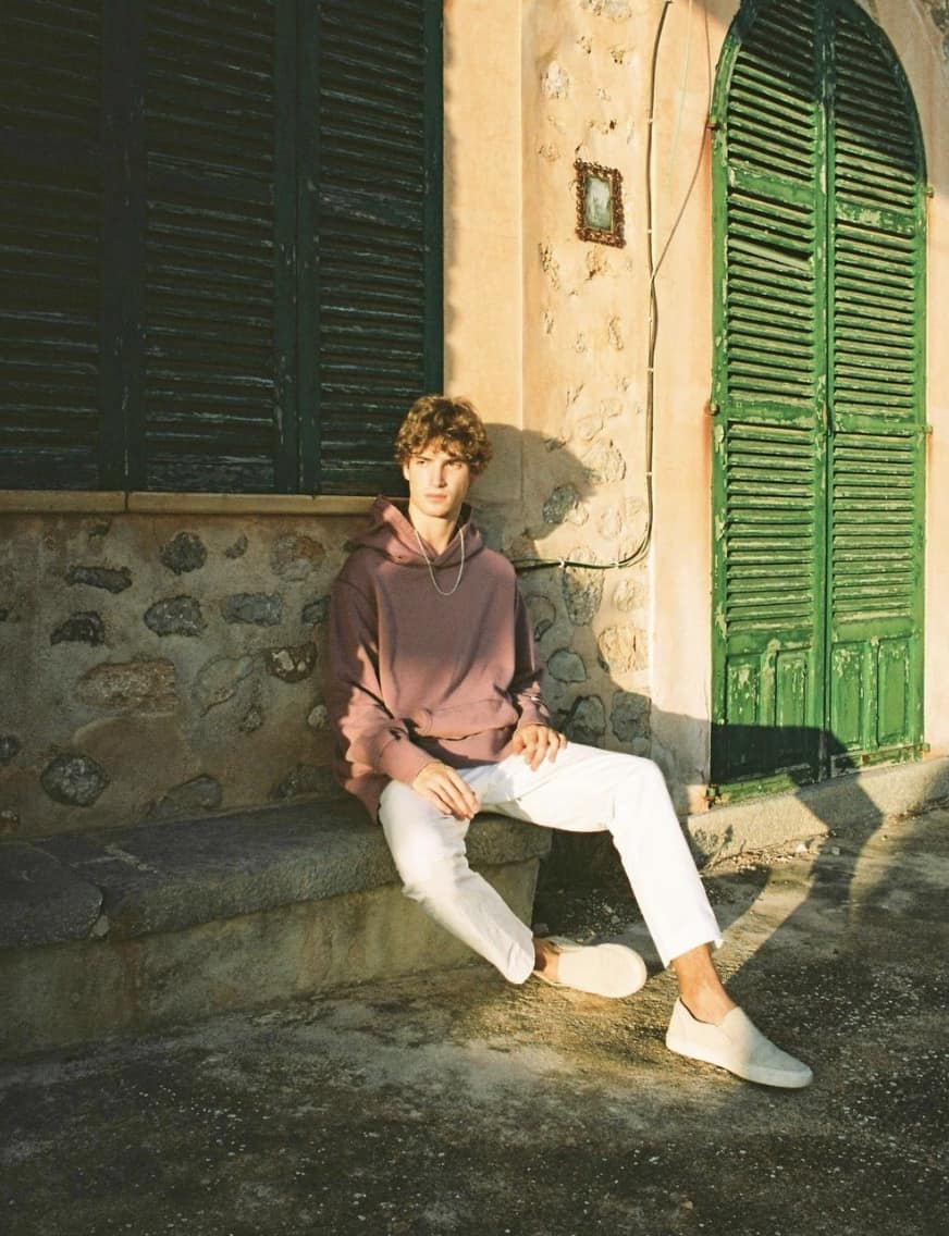 man sitting on the curb in the afternoon sun