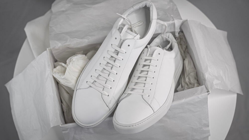 Oliver Cabell Low 1s on top of an opened shoe box