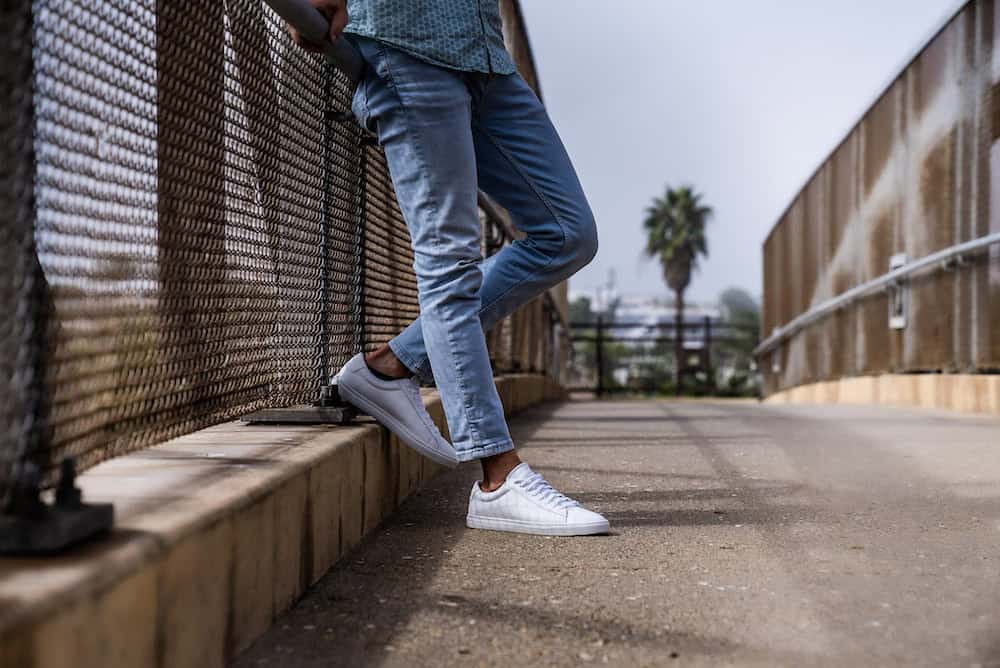 Man leaning against a bridge railing highlighting Oliver Cabell Low 1s