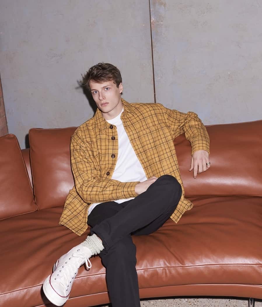 man leaning back on a couch, looking straight into the camera