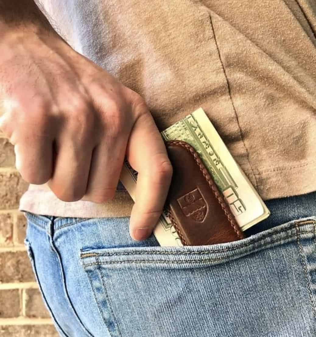 man pulling money clip out of back pocket