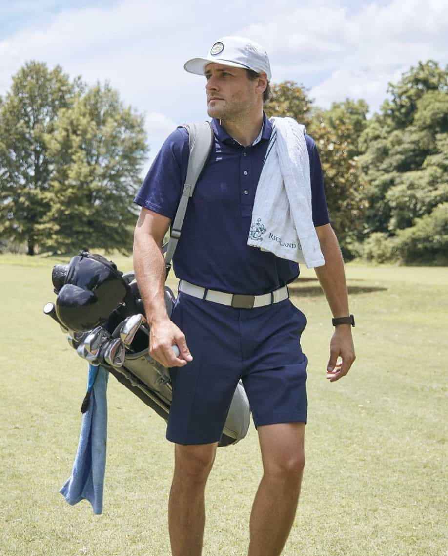 man walking, carrying golf club