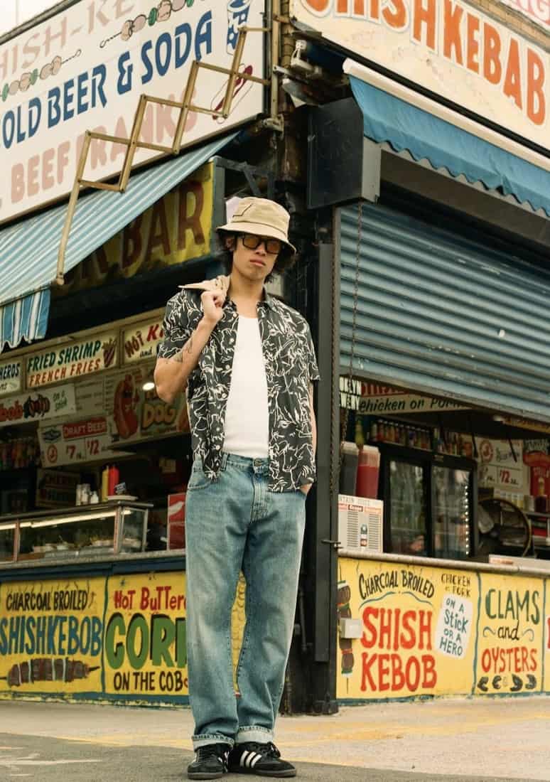 Man standing in front of a store wearing Corridor NYC clothing