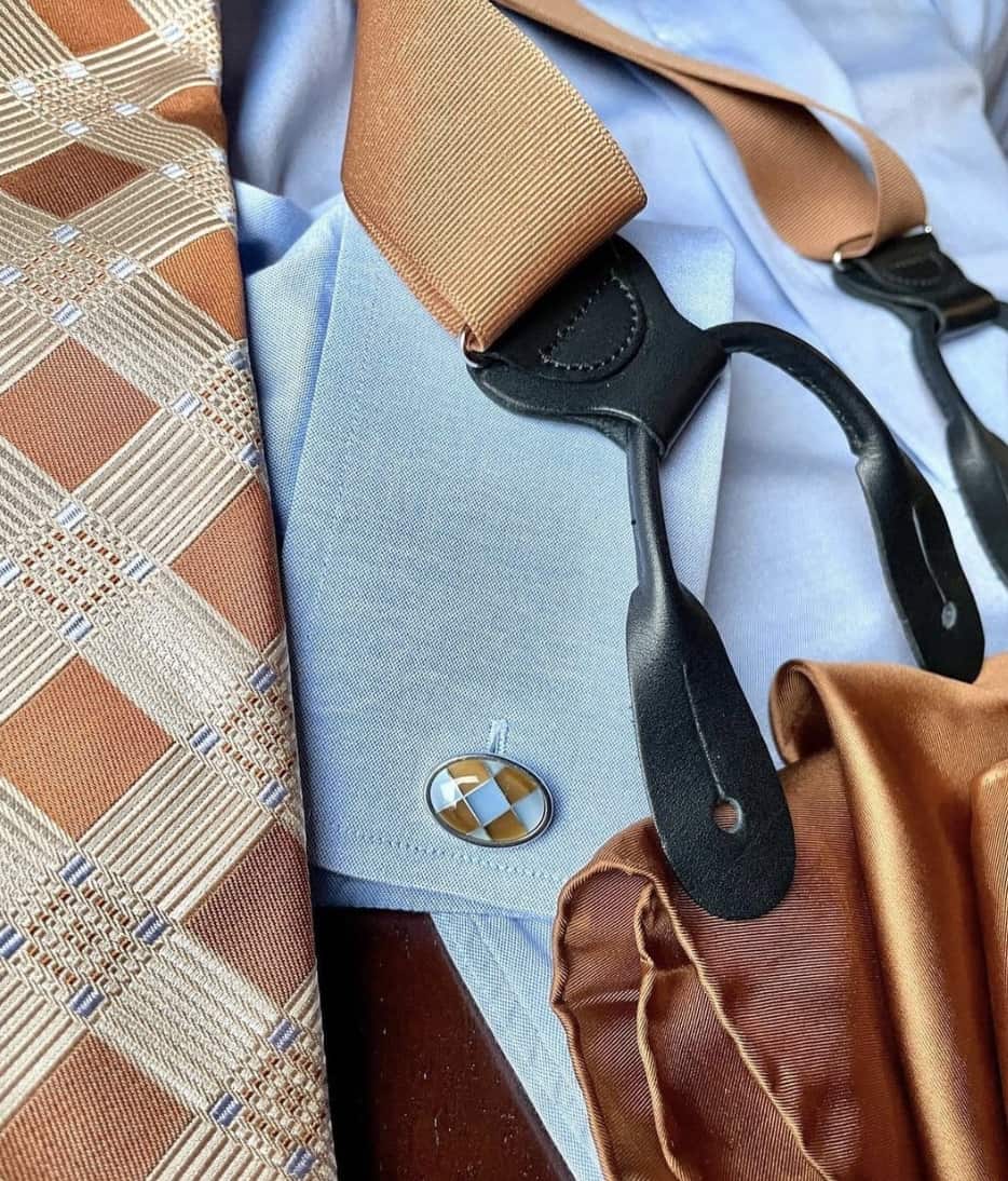 flat lay of a tie, suspenders and dress shirt