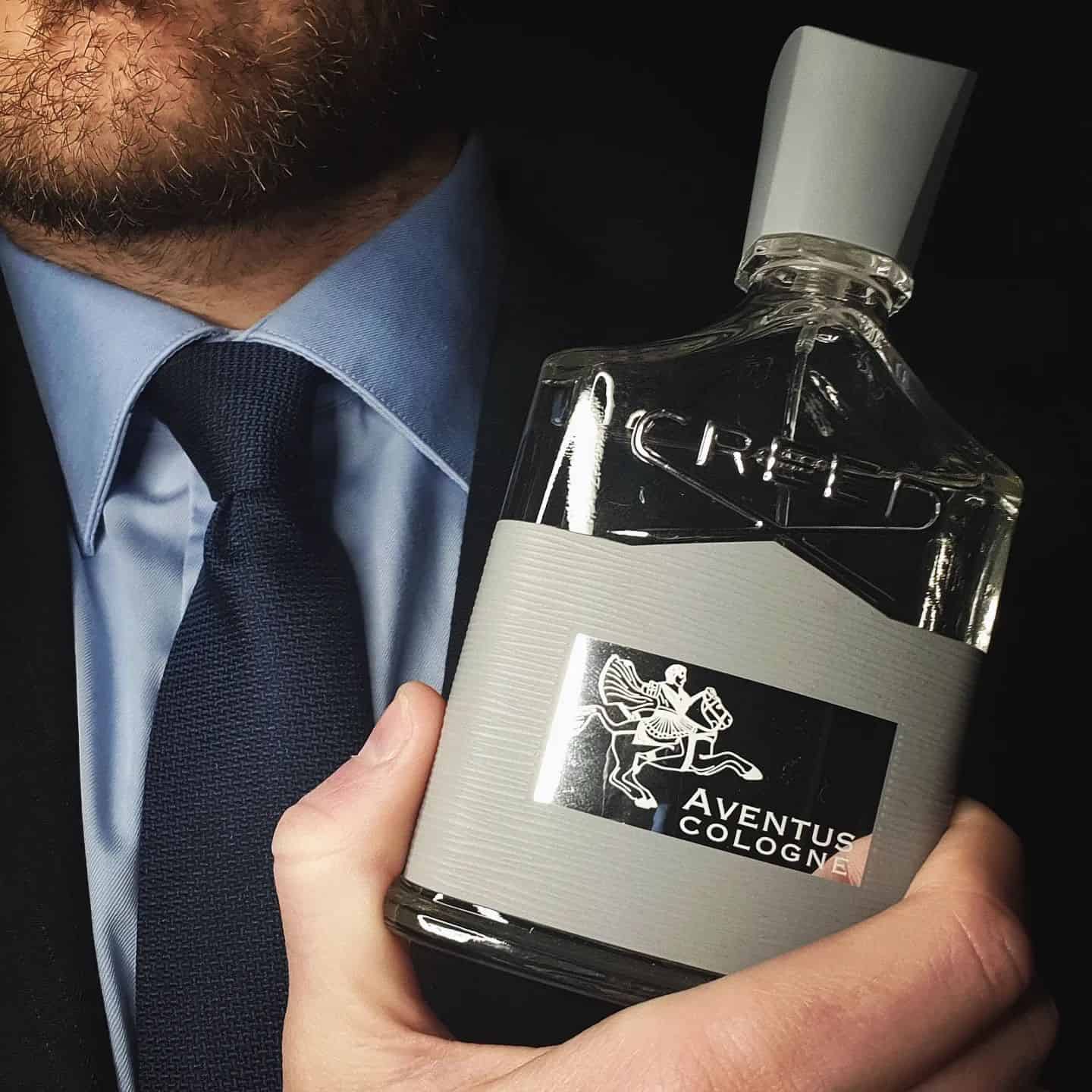 Holding a bottle of Creed Aventus