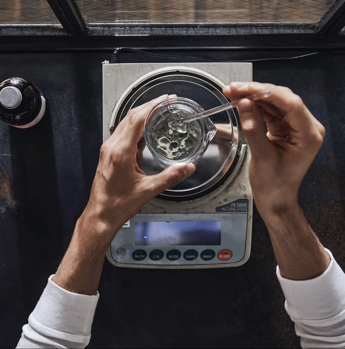 person making cologne on a scale