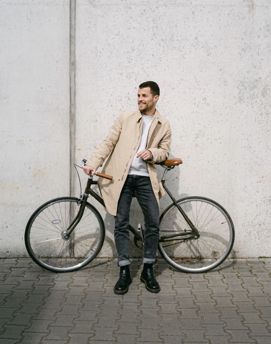 man leaning on a bike against a wall 