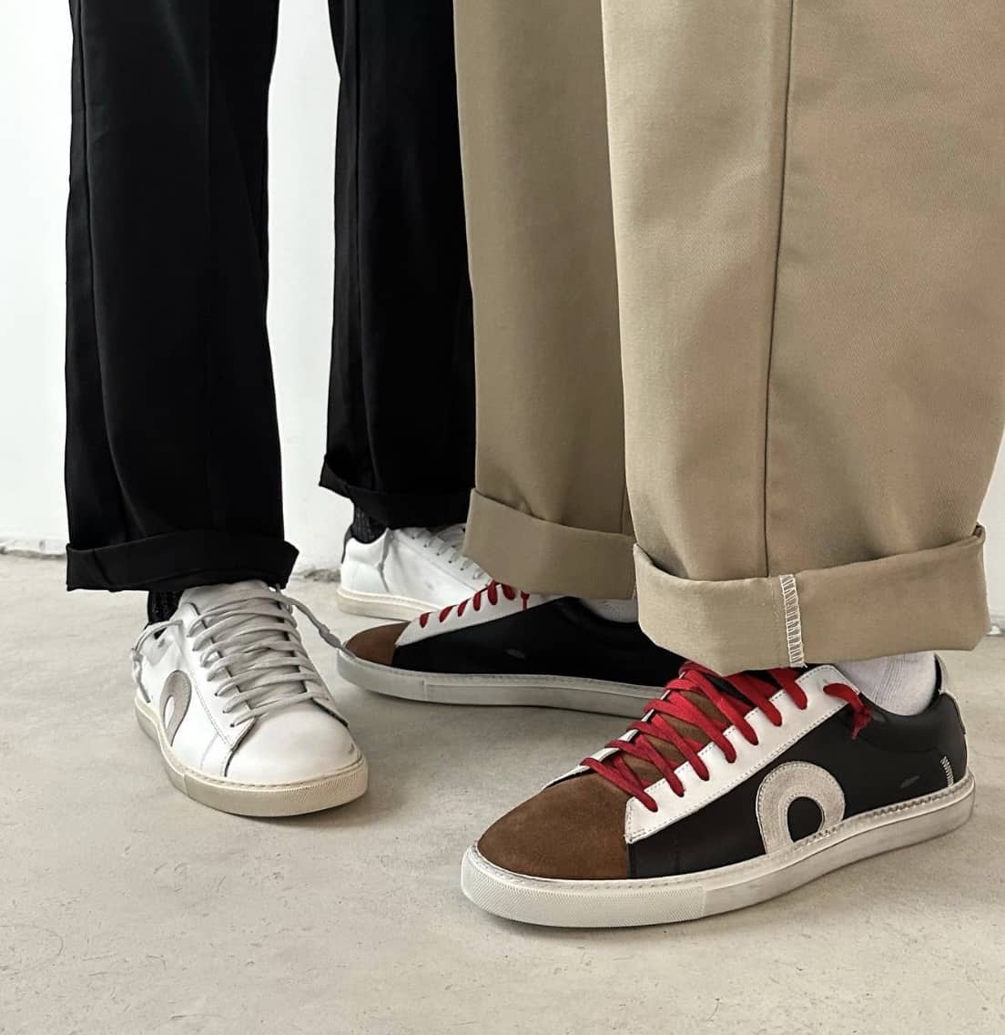 two sets of feet, wearing Oliver Cabell sneakers