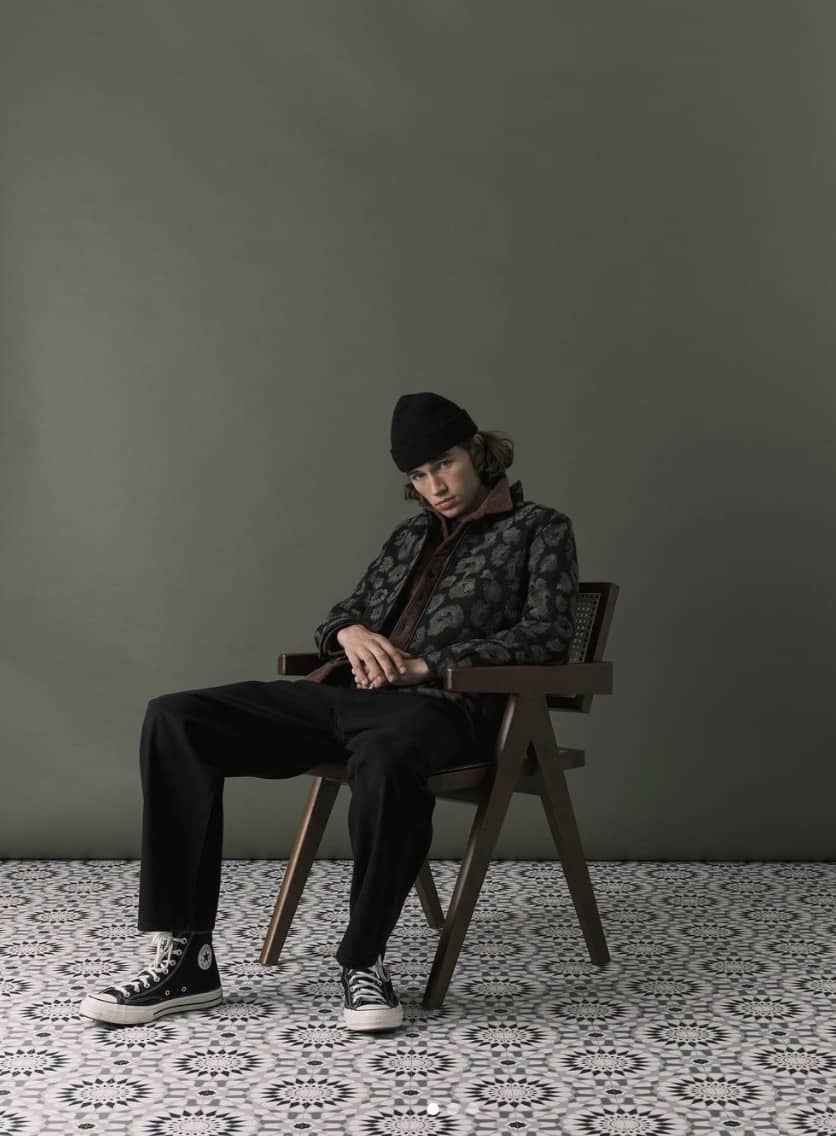 man sitting on a chair in a blank green room