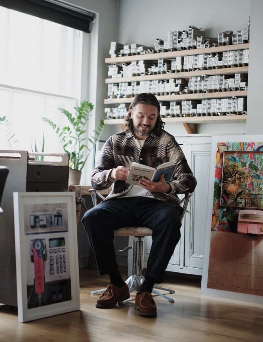 Man sitting in a chair, smiling reading a book