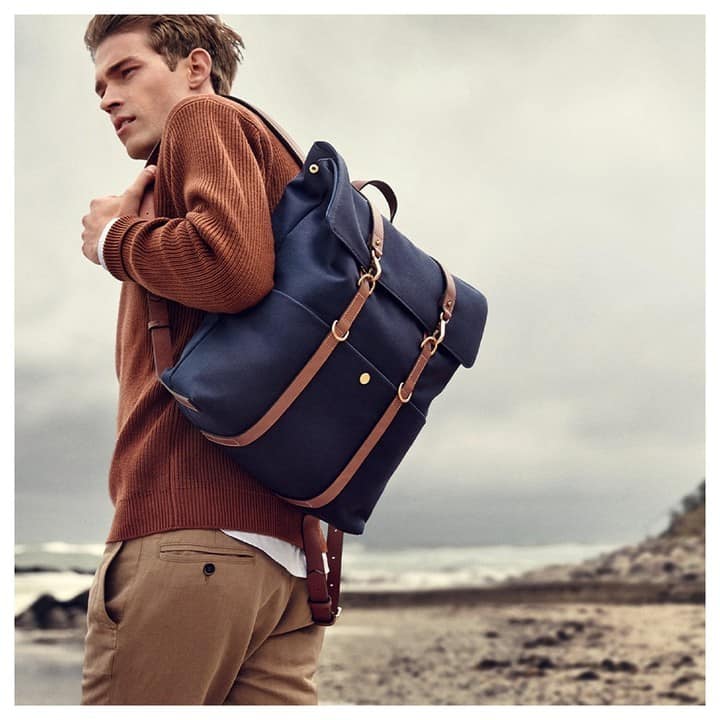 carrying a MS multi-function backpack by Mismo by the beach