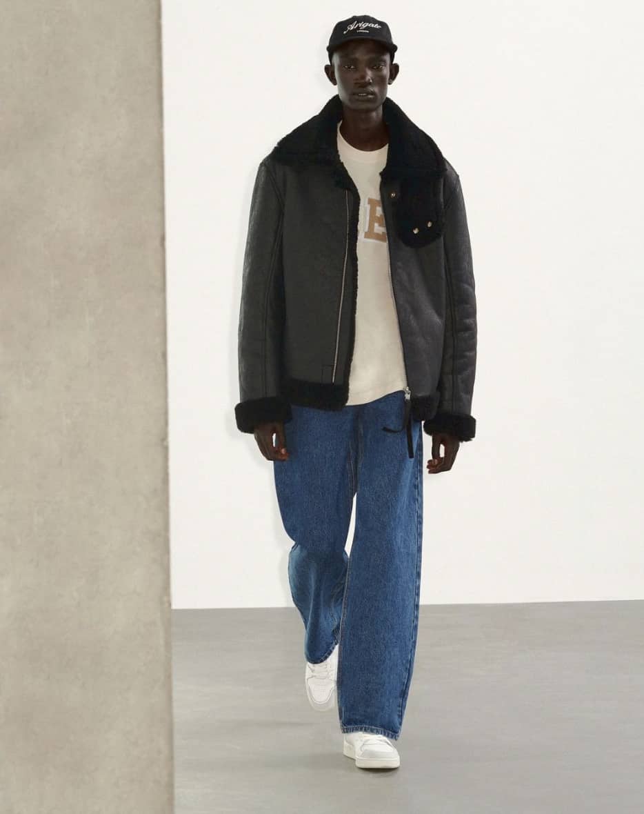 man walking showing off Axel Arigato clothing