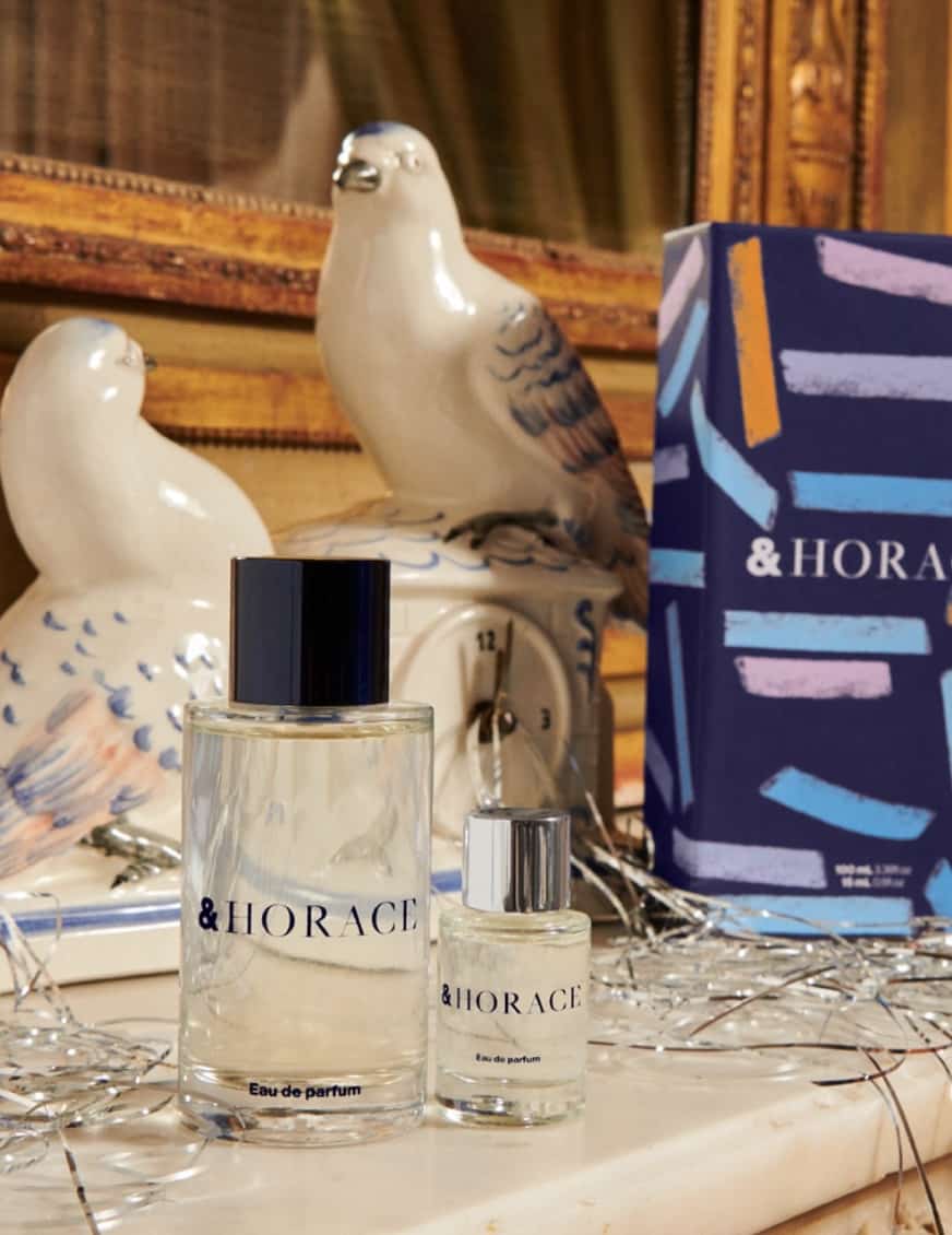 bottle of cologne on a shelf with bird statues and product boxes in the background