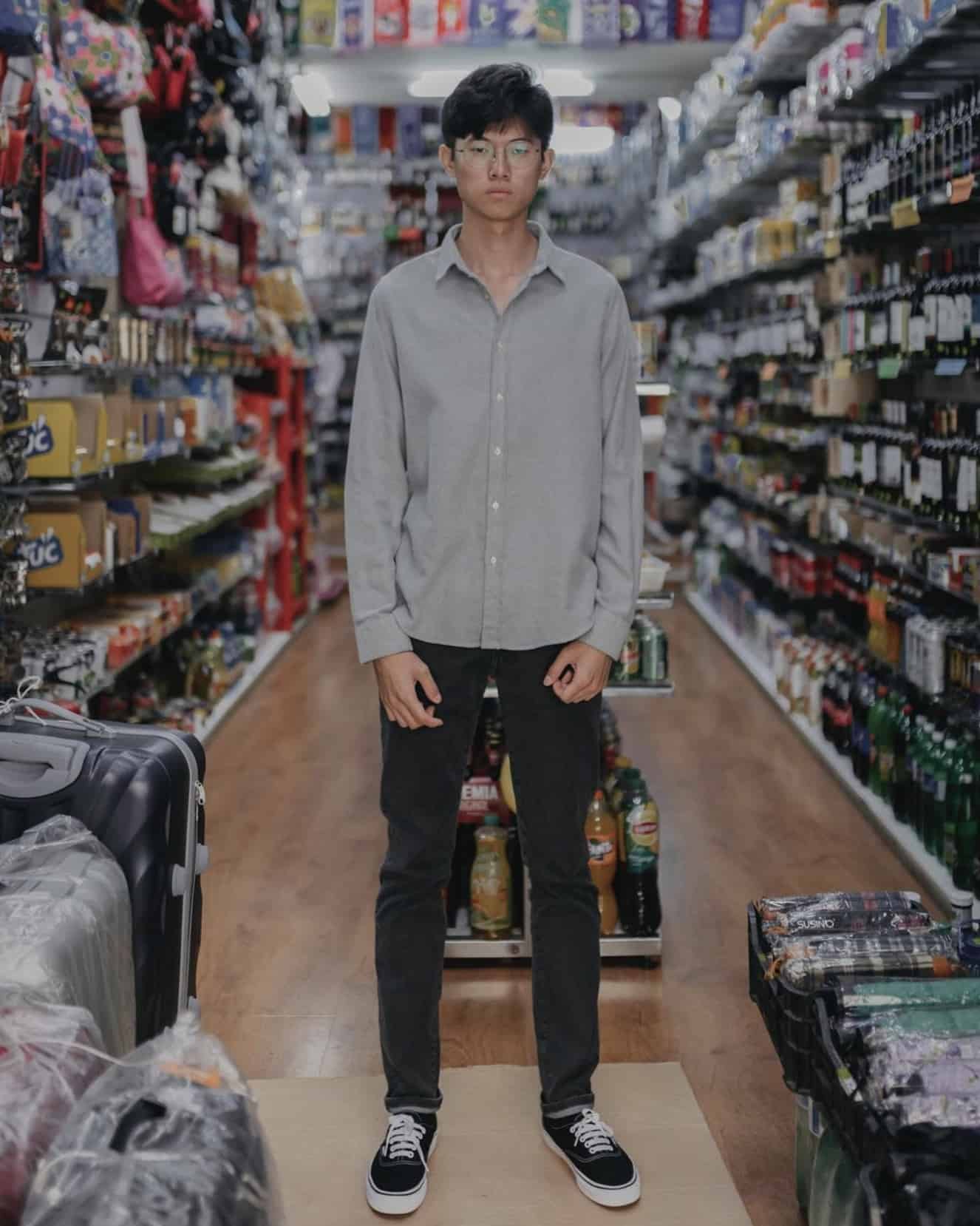 man stood in a shop wearing a grey flannel shirt