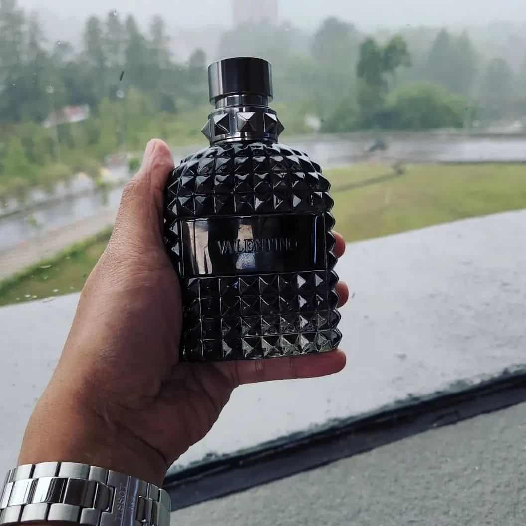 holding a bottle of valentino intense