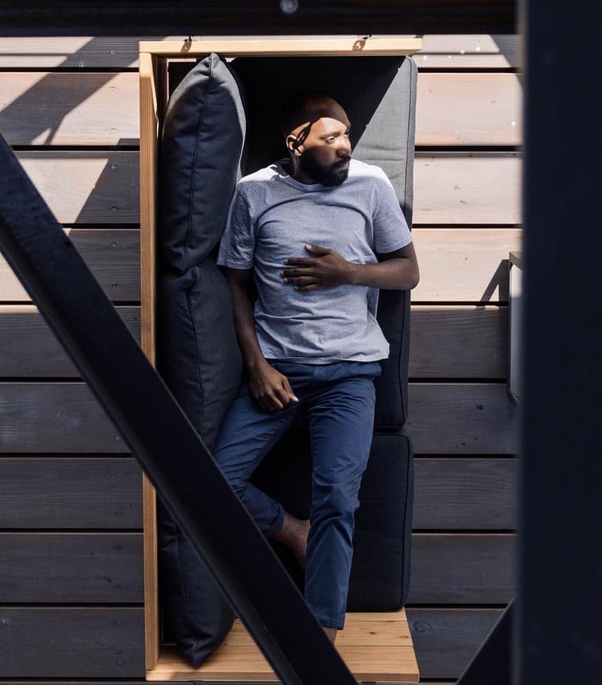 man laying on a couch in t-shirt and jeans
