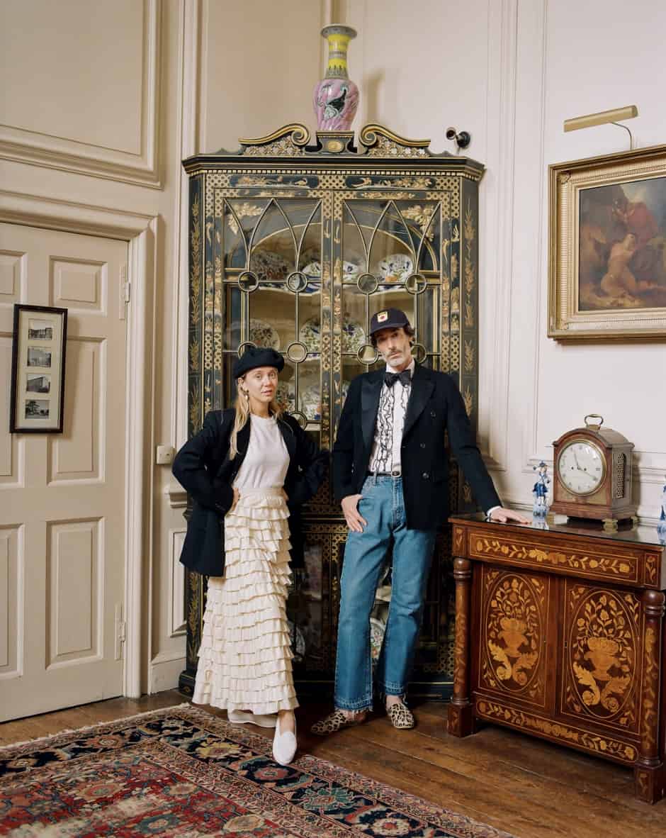man and women standing in the corner of a room, looking at the camera