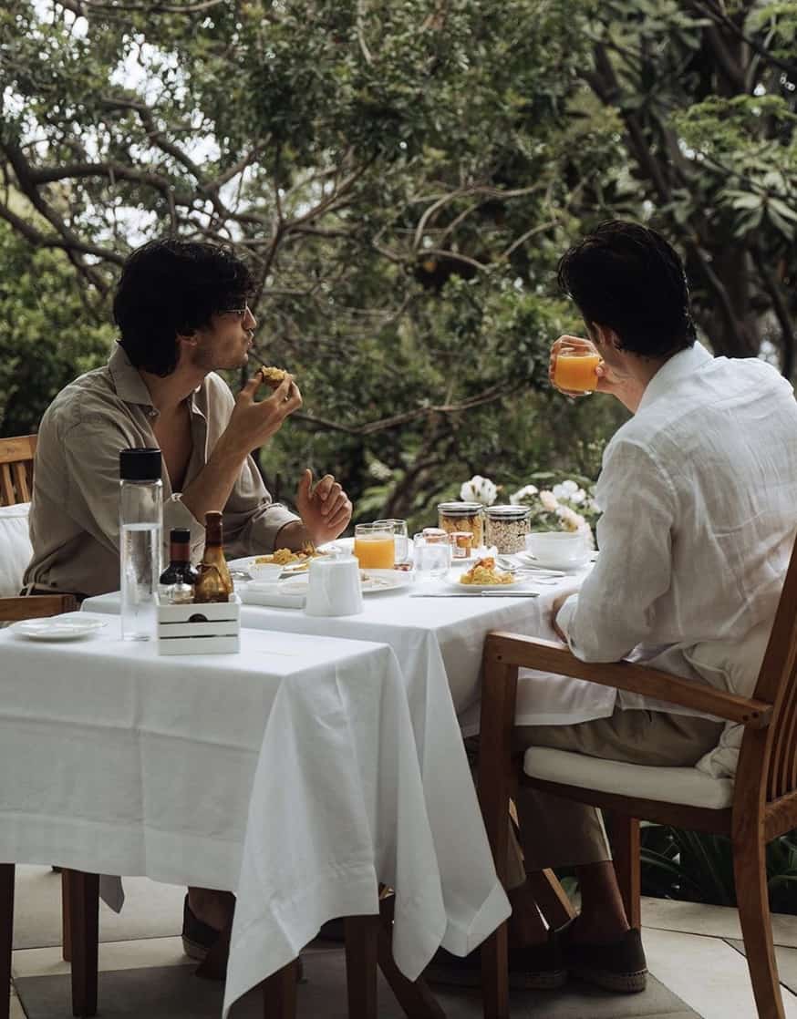 two men eating outside